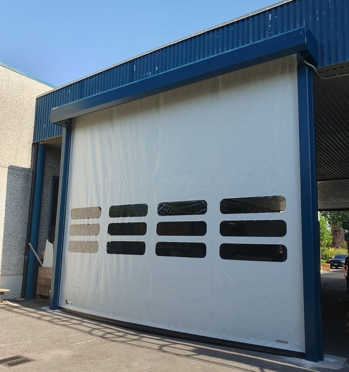 Porta rapida bianca con finestrature su capannone a Torino