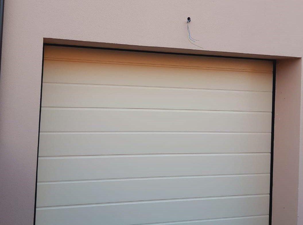 Porta sezionale bianca a doghe per garage residenziale a Torino