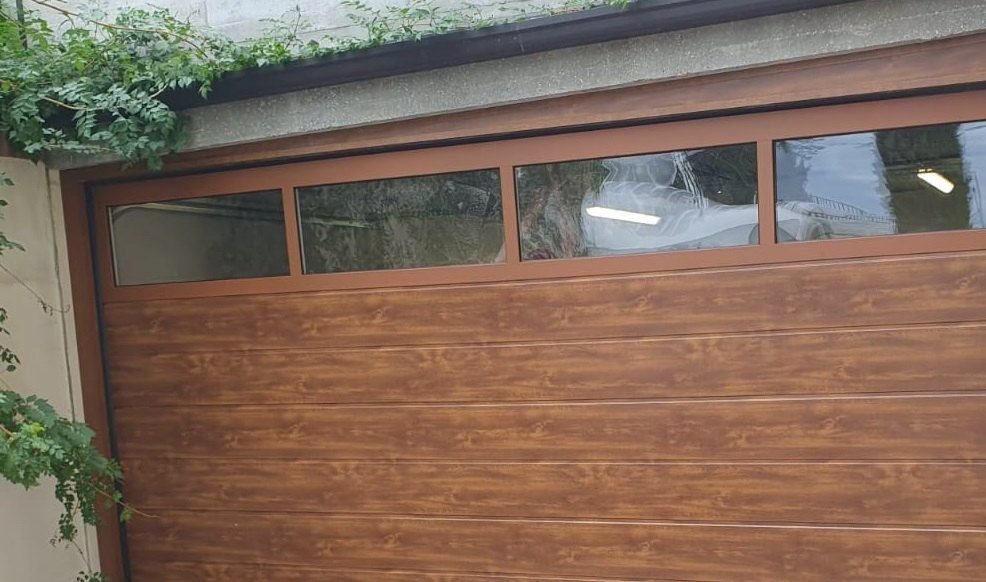 Porta sezionale effetto legno con finestrature per garage a Torino