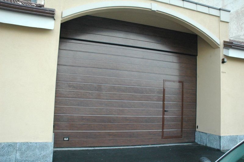 Porta sezionale marrone con porta pedonale inserita a Torino