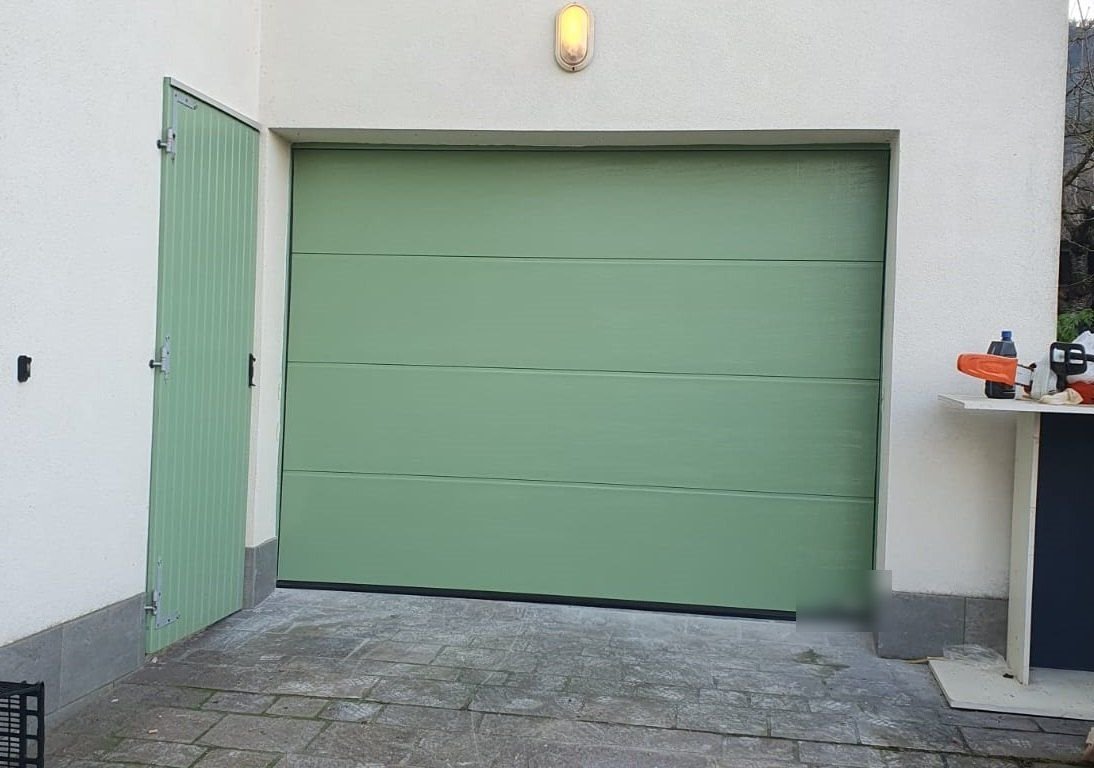 Porta sezionale verde con porta pedonale laterale a Torino