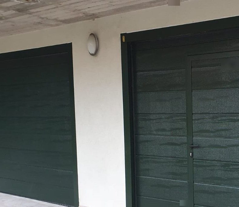 Porta sezionale e porta pedonale verdi coordinate a Torino