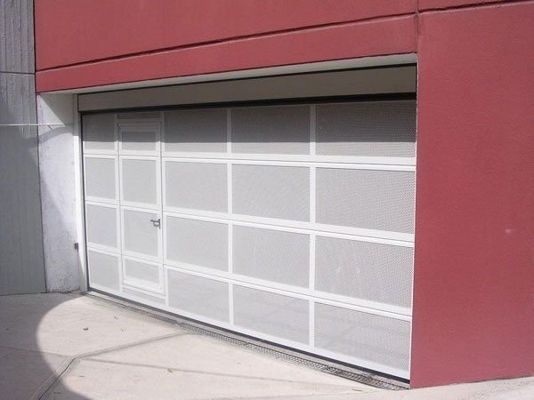 Portone sezionale full vision con porta pedonale per attività a Torino