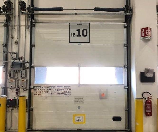 Portone sezionale industriale motorizzato in un magazzino di Torino